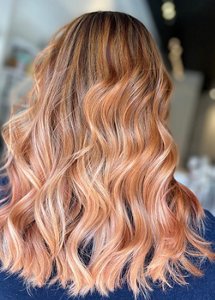 Woman with long hair with a rose gold balayage look